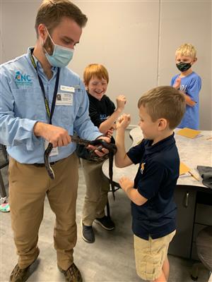student touching snake